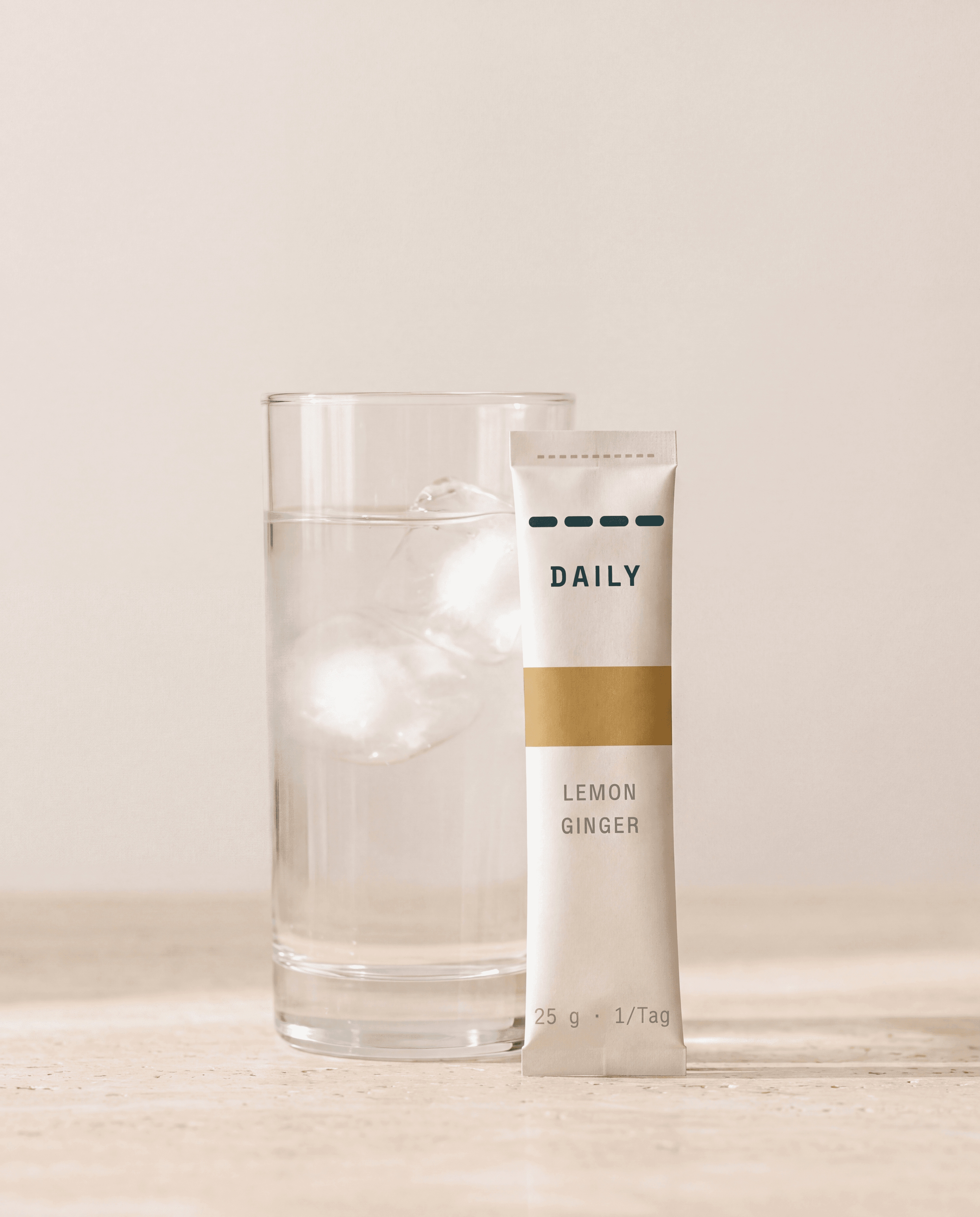 DAILY HEIST Stick neben einem Glas Wasser mit Eiswürfeln